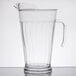 A clear plastic pitcher with a handle.