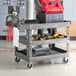 A man using a Lavex utility cart with built-in tool compartments to hold tools.