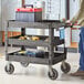 A man pushing a black Lavex utility cart full of tools.