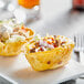 A white plate with two taco bowls made from tortillas.