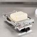 A Nemco Mozzarella Cheese Slicer with a 5/16" slicing arm slicing a block of cheese.