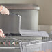 A person holding a 14 1/2" x 6" fryer basket with food in it.