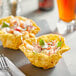 A table with two tortilla cups filled with food.