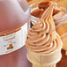 A scoop of caramel ice cream with a bottle of LorAnn Oils caramel flavor on a table.