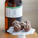 A white plate of chocolate truffles next to a bottle of LorAnn Oils Irish Cream flavor.