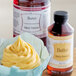A cupcake with yellow frosting next to a bottle of LorAnn Oils Butter Bakery Emulsion.