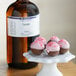 A white plate of chocolate truffles with pink frosting next to a bottle of LorAnn Oils Teaberry flavoring.