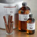 A glass cup of cinnamon sticks next to a bottle of LorAnn Oils Cinnamon Super Strength Flavor.