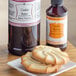 A plate of cookies with a jar of LorAnn Oils Cookie Butter Bakery Emulsion on the side.