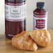 A bottle of LorAnn Buttery Sweet Dough emulsion next to croissants.