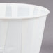 A Solo white paper souffle cup on a gray surface.