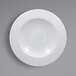 A close-up of a RAK Porcelain Helm white plate with a circular design.