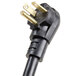 A close-up of a black power cord plug with two gold plugs.