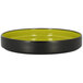 A green RAK Porcelain deep porcelain plate with a white rim on a yellow surface.