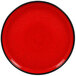 A red porcelain plate with a black rim.