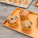 A Chicago Metallic bakery display tray with a muffin in a wrapper on it.
