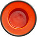 An orange porcelain saucer with a black rim.