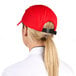 A woman wearing a red Headsweats 5-panel cap with a ponytail.