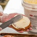 a person spreading butter on a roll