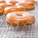 A glazed Rich's Honey Dip donut on a cooling rack.