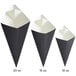 Three black and white Carnival King cardboard fry cones.