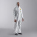 A man in white Cordova polypropylene coveralls with elastic wrists and a hood.