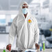A man wearing Cordova white protective coveralls with elastic wrists and a hood.