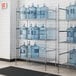 A Regency chrome wire shelving unit holding water jugs.