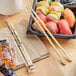 A pack of Emperor's Select 9-inch bamboo twin chopsticks placed next to sushi and condiments.
