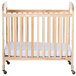 A natural wood crib with adjustable mattress board and white sheets.