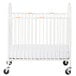 A white Foundations steel folding crib with wheels.