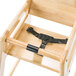 A Foundations wooden high chair with a black strap.