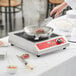 A person cooking a piece of meat on an Avantco countertop induction range.