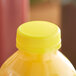 A close-up of a yellow plastic bottle cap on a yellow bottle.