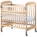A natural wood crib with a clearview end and wheels.