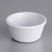 A white fluted Acopa ramekin on a gray surface.