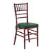 A mahogany wood Chiavari chair with a green cushion.