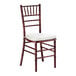 A mahogany wood Chiavari chair with an ivory cushion.