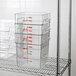 A metal rack with a stack of Cambro clear plastic containers.