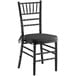 A Lancaster Table & Seating black wood chiavari chair with black cushion.