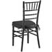 A Lancaster Table & Seating black Chiavari chair with black cushion.