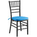 A black Lancaster Table & Seating Chiavari chair with a blue cushion.