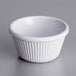 An Acopa white fluted melamine ramekin on a gray surface.