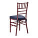 A mahogany wood Chiavari chair with a navy blue cushion.