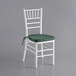 A white Lancaster Table & Seating Chiavari chair with a green cushion.