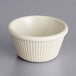 An Acopa bone white fluted melamine ramekin on a gray surface.