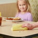 A hand using a yellow ChoiceHD foodservice wiper to wipe a table.