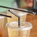 A close-up of a Choice jumbo black flex straw in a plastic cup.