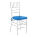 A white wood Chiavari chair with a blue seat cushion.