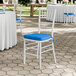 A white wood Chiavari chair with a blue cushion.